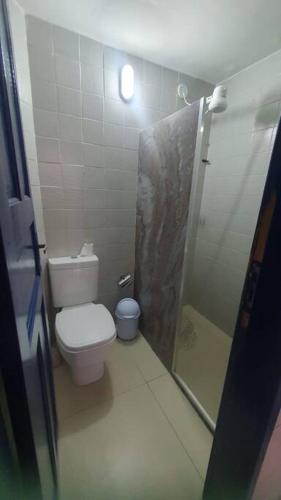 a small bathroom with a toilet and a shower at Casa da Margarida em Arraial do Cabo in Arraial do Cabo