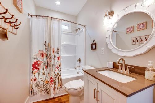 a bathroom with a sink and a toilet and a mirror at Lakefront New London Retreat with Dock and Hot Tub! in New London