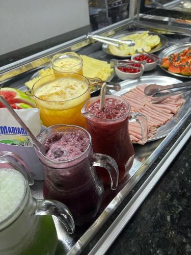 ein Tablett mit Speisen und zwei Einmachgläsern, die mit Essen gefüllt sind in der Unterkunft Hotel e Restaurante Chão Nativo in São José da Barra