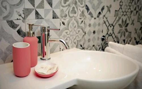 阿梅利亞的住宿－Debirooms，一间带水槽和粉色肥皂机的浴室