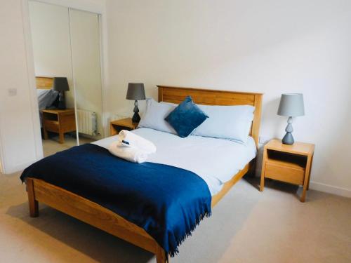a bedroom with a large bed with blue and white pillows at Brand new gorgeous 2 bed Apt in Finnieston in Glasgow