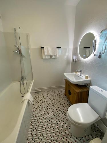 a white bathroom with a toilet and a sink at Balzac Hôtel Restaurant in Fougères