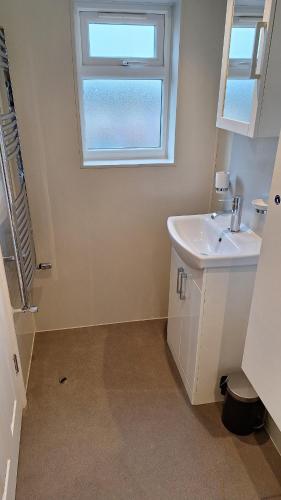 uma casa de banho com um lavatório e uma janela em NEW 2 bedrooms with private ensuite bathrooms near Heathrow em Ashford