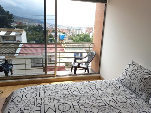 een slaapkamer met een bed en een groot raam bij Hermoso, Apacible - Apartamento Central - Tunja in Tunja