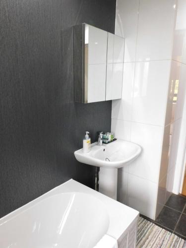 a white bathroom with a sink and a bath tub at Charming 2 bed apt close to City and SEC Hydro in Glasgow