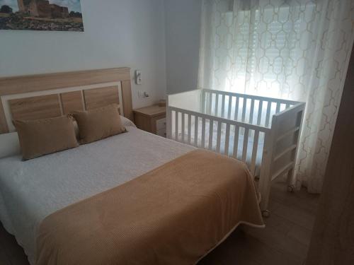 a bedroom with a bed and a crib at CASA GODOY in Cáceres