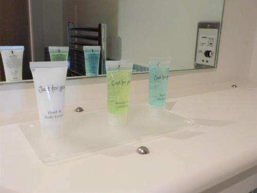 a bathroom counter with two cups on a sink at 2 Bedroom Apt in the Heart of the City Centre, perfect Location in Glasgow