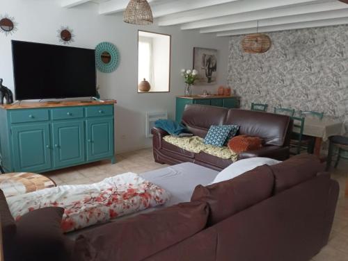 a living room with two couches and a flat screen tv at La Montournaise in Montournais