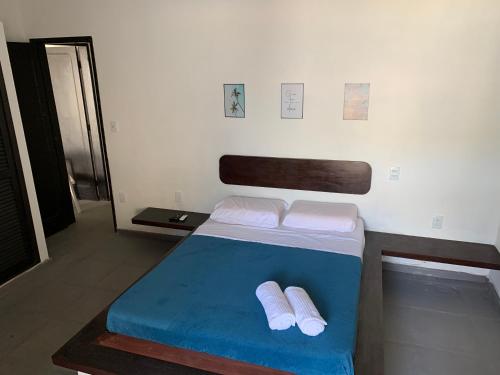 a bedroom with a bed with two white towels at Hostel Vila dos Corais in Arraial do Cabo