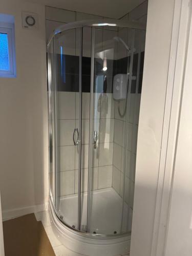 a shower with a glass door in a bathroom at House to rent in Derby