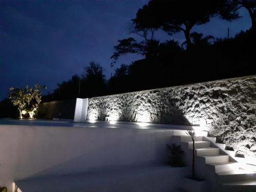 a set of stairs in front of a stone wall at night at Villa INARIME in Ischia