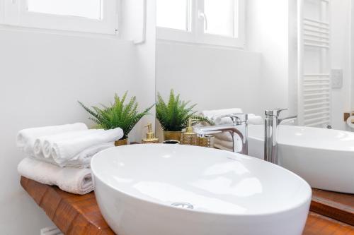 een badkamer met een wit bad en een wastafel bij Loft Salgari in Turijn