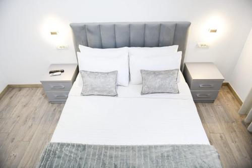 1 dormitorio con 1 cama blanca grande y 2 mesitas de noche en Villa Kaceli en Berat