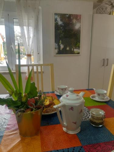 a table with a tea kettle and a plate of food at O Mundo da Lua in Azeitao
