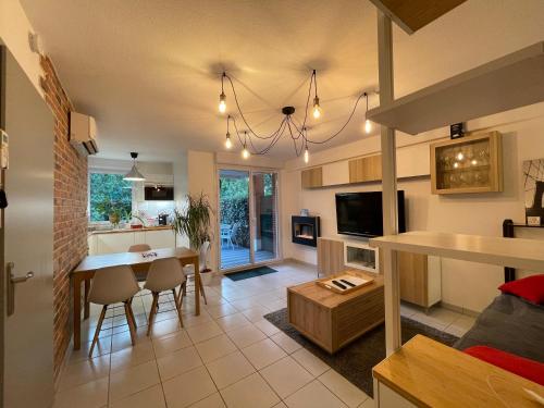 une cuisine et un salon avec une table et des chaises dans l'établissement Manoir by Yumē, à Toulouse