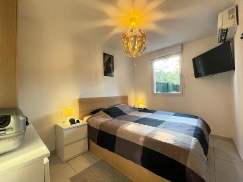 une chambre avec un lit et un lustre dans l'établissement Manoir by Yumē, à Toulouse