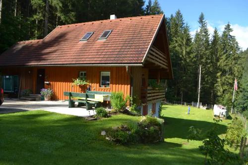 ein Haus mit einer Bank davor in der Unterkunft Ferienhaus Waldenstein 1 in Wolfsberg