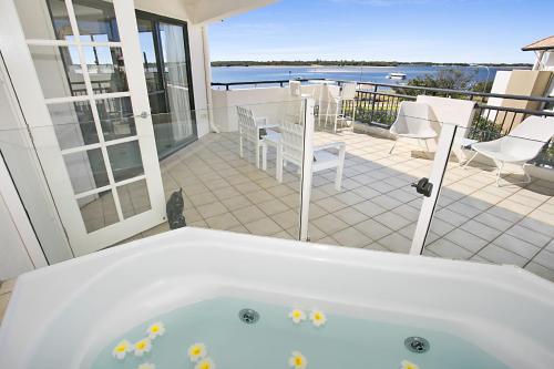 a bath room with a tub and a balcony at Sandcastles On The Broadwater in Gold Coast