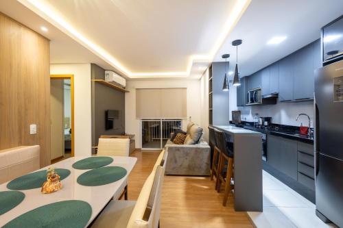 eine Küche und ein Wohnzimmer mit einem Esstisch und einer Küche in der Unterkunft Aptos completos com vista mar pé na areia em Barra Velha em condomínio Resort com Spa, Piscina, quadra de futebol, Sala de jogos, brinquedoteca, Complexo com diversos comércios in Barra Velha