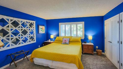 Dormitorio azul con cama con colcha amarilla en Sunset Serenade in Welaka en Georgetown