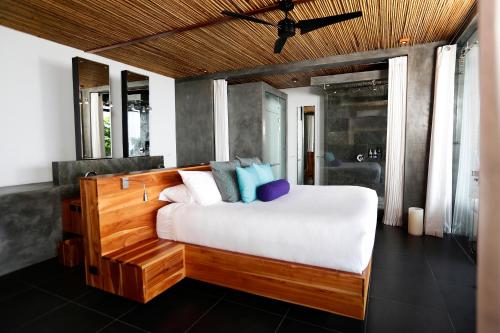 a bedroom with a large white bed with blue pillows at Kura Boutique Hotel Member of the Cayuga Collection in Uvita