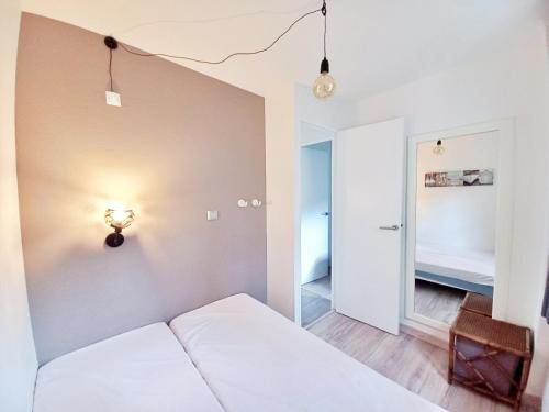 - une petite chambre avec un lit et une lumière sur le mur dans l'établissement 3 pièces tout confort à Cap Estérel, à Saint-Raphaël