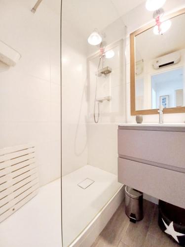 une salle de bain blanche avec une douche et un lavabo dans l'établissement 3 pièces tout confort à Cap Estérel, à Saint-Raphaël