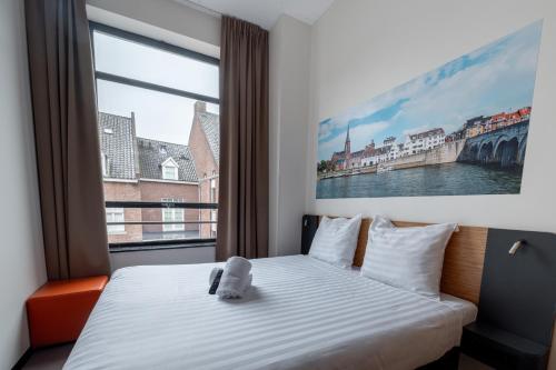 a bedroom with a bed and a large window at easyHotel Maastricht City Centre in Maastricht