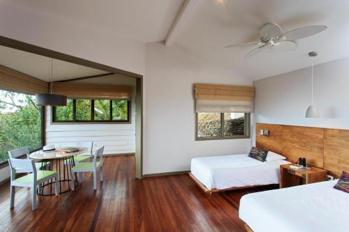a bedroom with a bed and a dining room with a table at Senda Monteverde Hotel Member of the Cayuga Collection in Monteverde Costa Rica