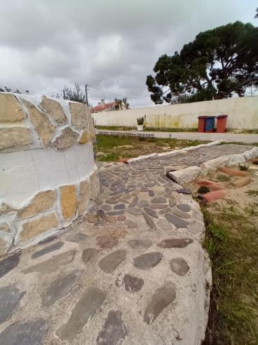 a stone walkway next to a stone wall at O Mundo da Lua in Azeitao