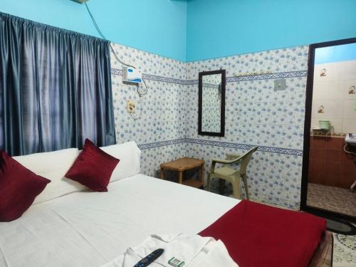 a bedroom with a bed with red pillows and a mirror at Sri Kanya Residency, Srikalahasti in Srikalahasti