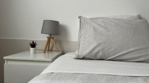 a bed with a pillow and a table with a lamp at Espírito Azul Guest House - Rooms To Rent, 2 minutes walking from the beach, Marina and our Dive Center in Vila Franca do Campo