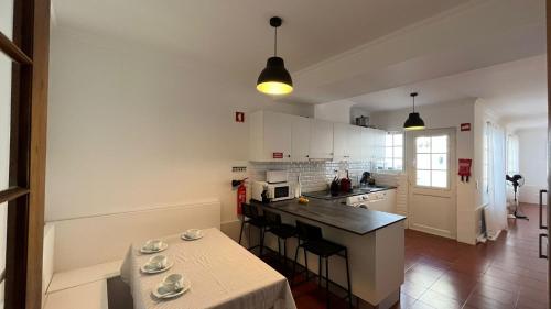 a kitchen with a table with chairs and a counter top at Espírito Azul Guest House - Rooms To Rent, 2 minutes walking from the beach, Marina and our Dive Center in Vila Franca do Campo