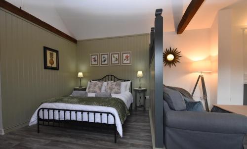 ein Schlafzimmer mit einem Bett und einem Sofa in der Unterkunft Daisy in Rye