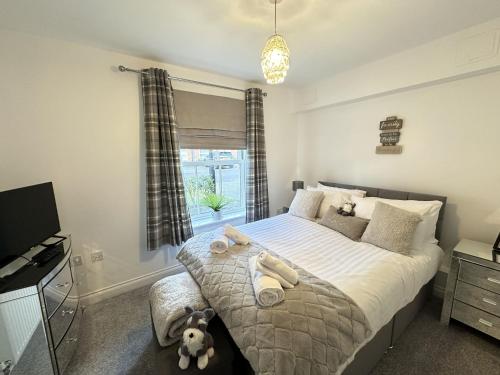 a bedroom with a bed with a teddy bear on it at Bliss On The Bay in Filey