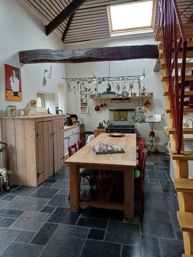 a kitchen with a wooden table in a room at Inne Schuur in Vlodrop