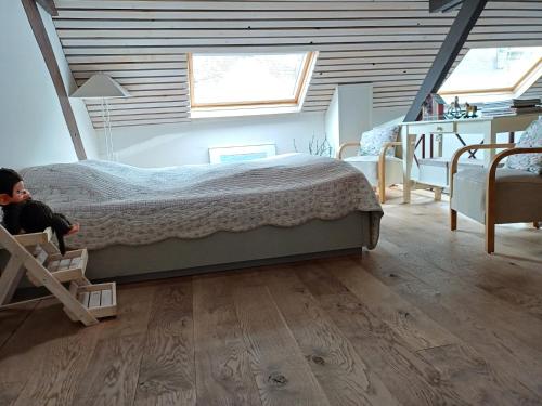 een slaapkamer met een groot bed op zolder bij Inne Schuur in Vlodrop