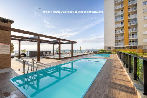 ein Schwimmbad auf dem Dach eines Gebäudes in der Unterkunft Aptos completos com vista mar pé na areia em Barra Velha em condomínio Resort com Spa, Piscina, quadra de futebol, Sala de jogos, brinquedoteca, Complexo com diversos comércios in Barra Velha