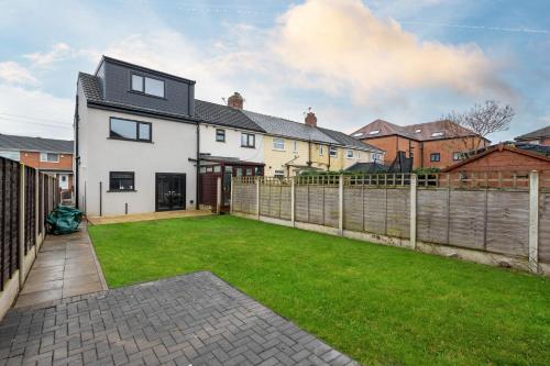 a house with a yard with a fence at Lofthouse M1 M62 - Parking, En-suite Bedrooms, Wi-Fi, Workspace, Smart TV's, Self Check-in, Garden - Contractors, Families, Long Stays - Alt-Stay in Wakefield