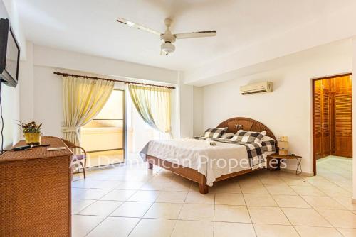 a bedroom with a bed and a tv in a room at Alicia Beach, Hispanola Sol, Sosua Center, guest friendly! in Sosúa