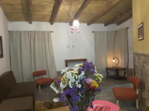 a living room with a vase of flowers on a table at 4 ELEMENTOS in Huacalera