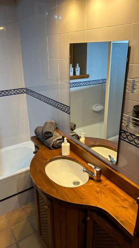 a bathroom with a sink and a mirror and a tub at Era Caseta - TREDÒS in Tredós