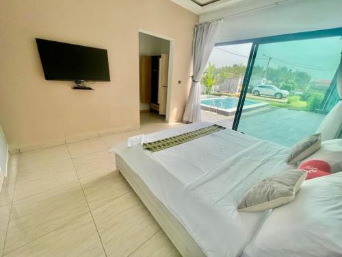 a large white bed in a room with a window at Les merveilles d’assinie in Assinie