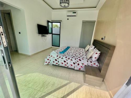 a bedroom with a bed and a tv in it at Les merveilles d’assinie in Assinie