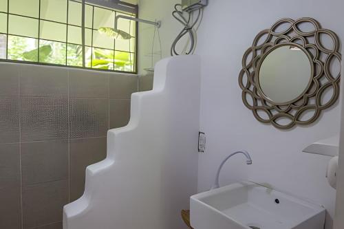 a bathroom with a sink and a mirror at Vishraam House ~ A pocos pasos de la playa in Cocles