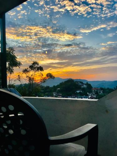 a chair sitting on a wall with a sunset at Cloud Nine in Kandy