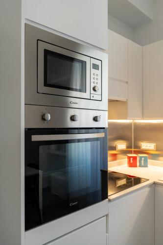 a microwave above a oven in a kitchen at Damatti Appartamento in Messina