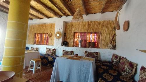 um quarto com uma mesa, cadeiras e janelas em Village donkey em Essaouira