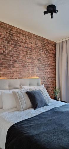 a bedroom with a brick wall and a large bed at Juuri valmistunut kaksio upealla Logomon alueella. in Turku