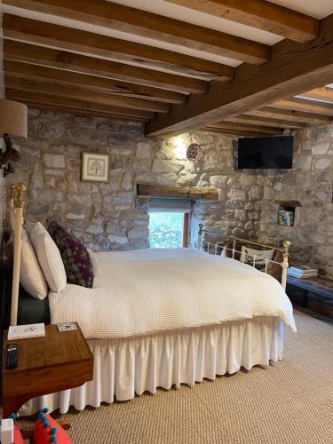 - une chambre avec un lit dans un mur en pierre dans l'établissement The Cowshed, à Llangollen
